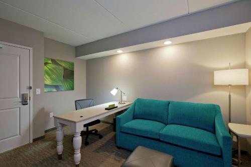 a living room with a couch and a desk and a table at Hilton Garden Inn Martinsburg in Martinsburg