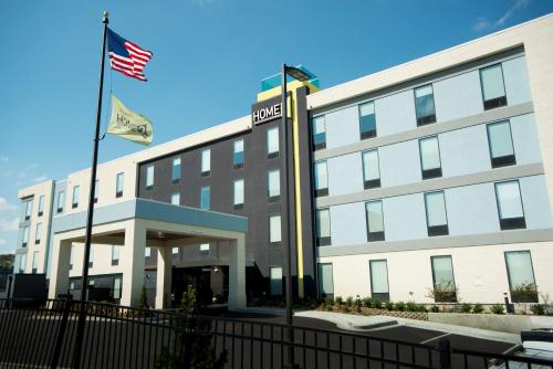 an office building with two flags in front of it at Home2 Suites by Hilton Tulsa Hills in Tulsa