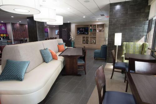 a living room with a couch and tables and chairs at Home2 Suites by Hilton Tulsa Hills in Tulsa