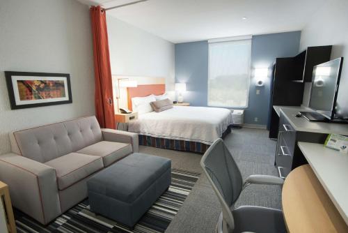 a hotel room with a bed and a couch at Home2 Suites by Hilton Tulsa Hills in Tulsa