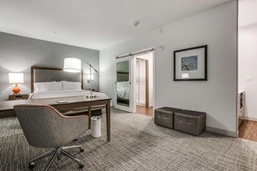 a hotel room with a bed and a desk and a bedroom at Hampton Inn & Suites Dallas-Central Expy/North Park Area in Dallas
