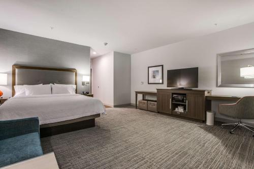 a hotel room with a bed and a flat screen tv at Hampton Inn & Suites Dallas-Central Expy/North Park Area in Dallas