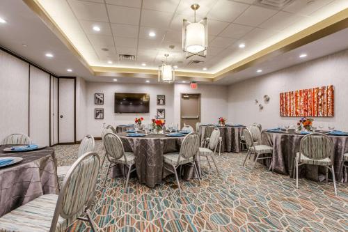 a conference room with tables and chairs and a screen at Hampton Inn & Suites Dallas-Central Expy/North Park Area in Dallas
