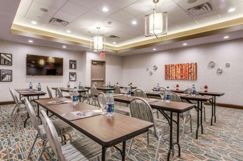 a conference room with tables and chairs and a screen at Hampton Inn & Suites Dallas-Central Expy/North Park Area in Dallas