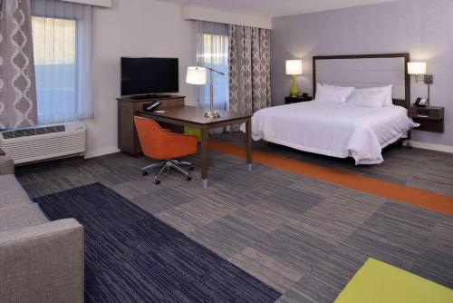 イースト・グリーンバッシュにあるHampton Inn & Suites Albany-East Greenbush, NYのベッドとデスクが備わるホテルルームです。