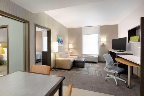 a living room with a couch and a desk at Home2 Suites By Hilton Billings in Billings