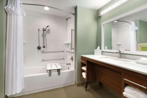 uma casa de banho com uma banheira, um chuveiro e um lavatório. em Home2 Suites By Hilton Billings em Billings