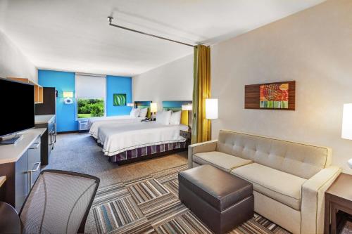 冈萨雷斯Home2 Suites By Hilton Gonzales的配有床和沙发的酒店房间