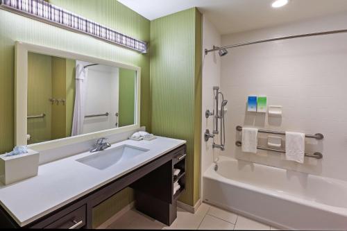 Home2 Suites By Hilton Gonzales في غونزاليس: حمام مع حوض وحوض ومرآة