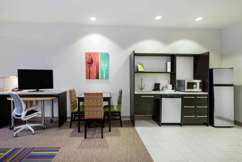 a room with a table and chairs and a kitchen at Home2 Suites By Hilton Austin Airport in Austin