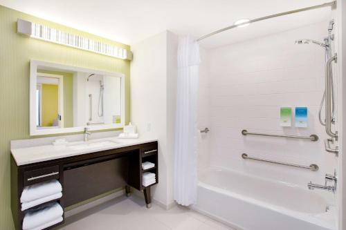 y baño con bañera, lavamanos y ducha. en Home2 Suites By Hilton Chicago Schaumburg, en Schaumburg