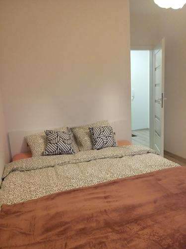 een slaapkamer met een groot bed met kussens erop bij Apartament Cztery Pory Roku Gdańsk in Gdańsk