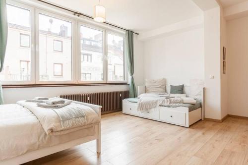 a bedroom with two beds and a large window at Stilvolles Apartment für 4 Pers. in Bremen