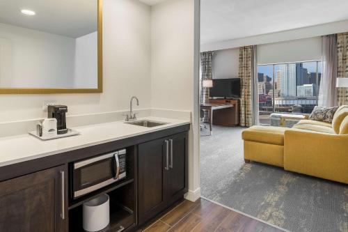 紐波特的住宿－肯塔基辛辛那提新港漢普頓套房汽車旅館，一间带水槽的厨房和一间带沙发的客厅