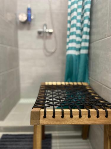 a wooden bench in a bathroom with a shower at Guesthouse Releash Aljezur in Aljezur