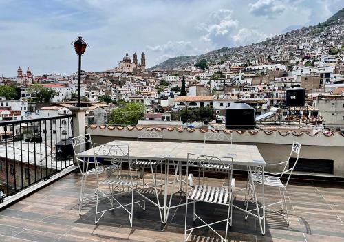 a table and chairs on a balcony with a view of a city at Casa céntrica con garaje in Taxco de Alarcón