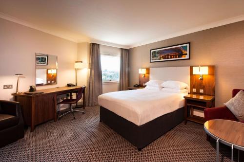 a hotel room with a bed and a desk at Doubletree By Hilton Glasgow Strathclyde in Bellshill