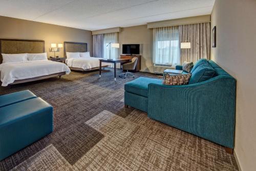 Hampton Inn & Suites By Hilton Nashville Hendersonville Tn في هينديرسونفيل: غرفة في الفندق مع أريكة وسرير