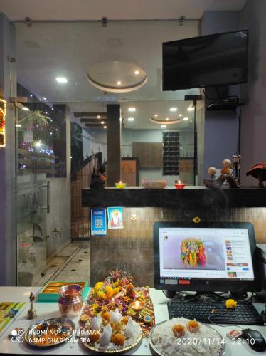um balcão com um computador e pratos de comida em Hotel Silk Inn Luxury At No Cost em Lucknow
