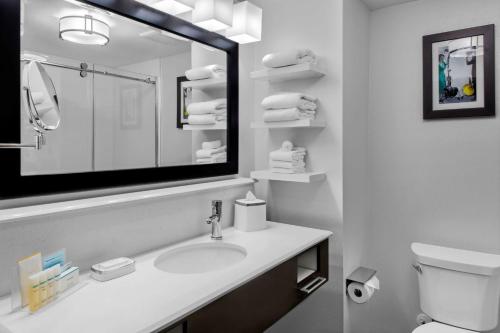 a white bathroom with a sink and a mirror at Hampton Inn & Suites Los Angeles/Hollywood, CA in Los Angeles