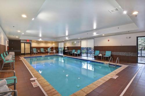 una gran piscina en un hotel con sillas y mesas en Hampton Inn Suites Ashland, Ohio, en Ashland