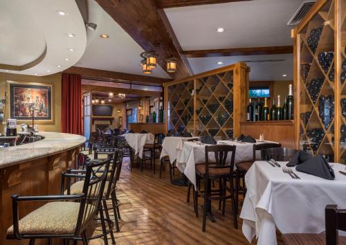 a restaurant with white tables and chairs and a bar at Hotel Park City, Autograph Collection in Park City