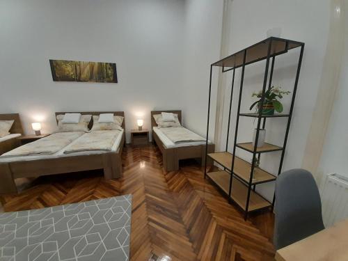 Habitación con 2 camas y estante en Déri Kert Apartmanház A, en Baja