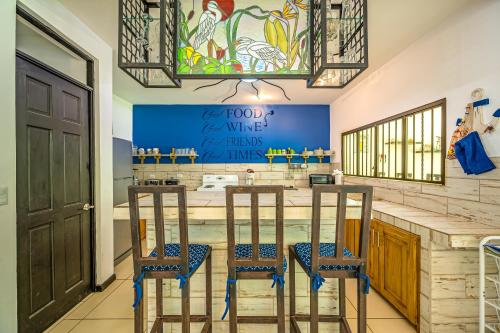a kitchen with a bar with three stools at Casa Sol in Carrillo