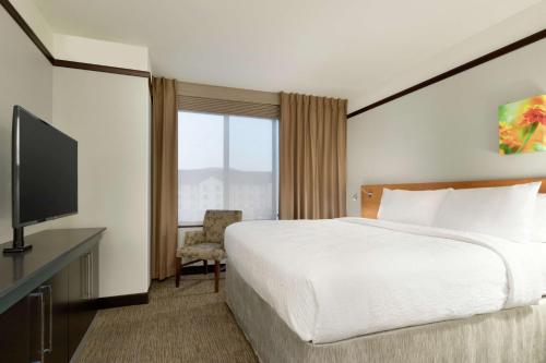 a hotel room with a bed and a television at Hilton Garden Inn Medford in Medford