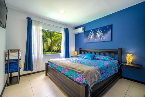 um quarto azul com uma cama e uma janela em Casa Sol em Carrillo