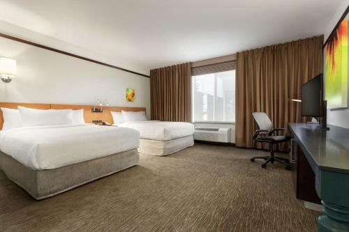 a hotel room with two beds and a desk at Hilton Garden Inn Medford in Medford