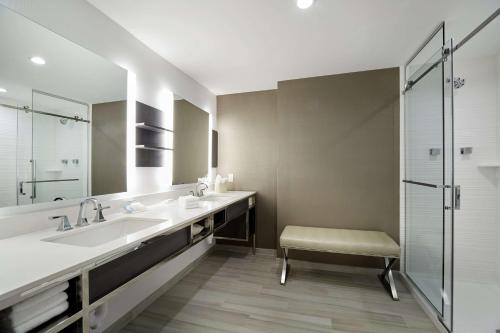 ein Badezimmer mit zwei Waschbecken und einer Glasdusche in der Unterkunft Hilton Garden Inn Roslyn in Roslyn