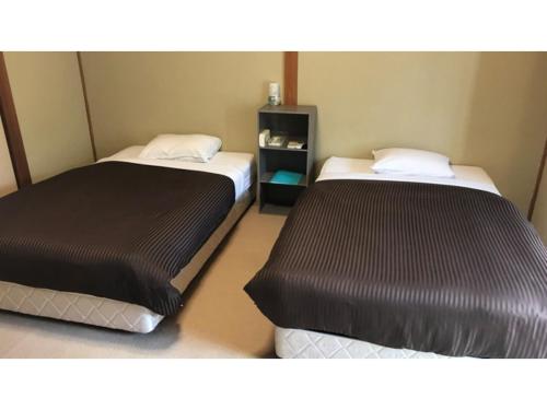 two beds in a small room withskirts at Biz Hotel Kiyura - Vacation STAY 93179v in Yura
