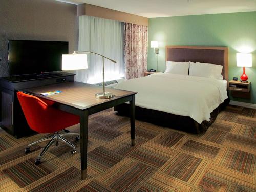a hotel room with a bed and a desk with a computer at Hampton Inn & Suites-Moore in Moore