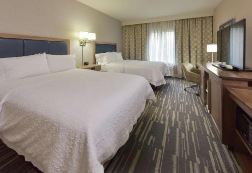 a hotel room with two beds and a television at Hampton Inn & Suites Seattle/Redmond Wa in Redmond