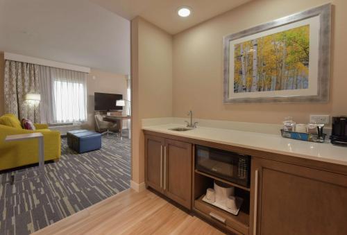 a kitchen with a sink and a living room at Hampton Inn & Suites Seattle/Redmond Wa in Redmond