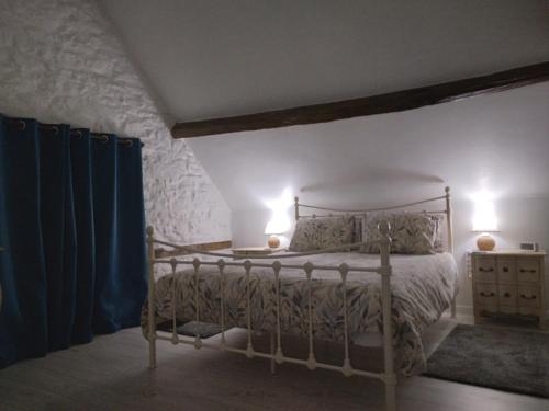 a bedroom with a bed with two lights on at Reids Retreat in La Roche-lʼAbeille