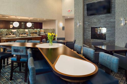a restaurant with tables and chairs and a bar at Homewood Suites by Hilton St. Louis Westport in Maryland Heights