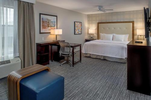 a hotel room with a bed and a desk and a computer at Homewood Suites by Hilton St. Louis Westport in Maryland Heights