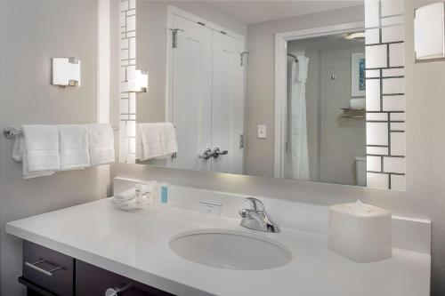 a white bathroom with a sink and a mirror at Homewood Suites by Hilton St. Louis Westport in Maryland Heights