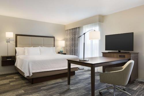 Niles的住宿－Hampton Inn & Suites Niles/Warren, OH，酒店客房配有一张床、一张书桌和一台电视。