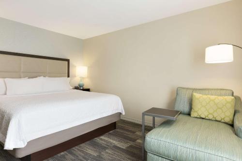 a hotel room with a bed and a chair at Hampton Inn & Suites Niles/Warren, OH in Niles