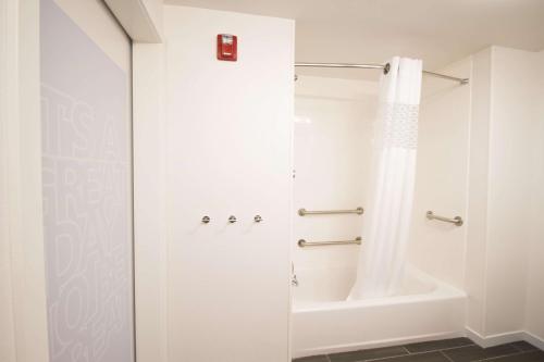 een witte badkamer met een douche en een bad bij Hampton Inn Decatur, Mt. Zion, IL in Decatur