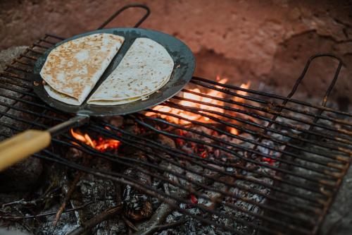 two pizzas cooking on top of a grill at Bäckalyckan in Röstånga