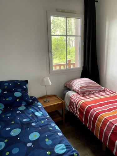 une chambre avec un lit et une fenêtre dans l'établissement Maison 3 pièces 6 personnes proche golf et océan, à Lacanau