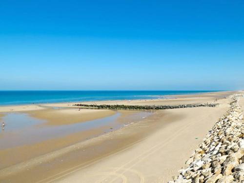 une plage de sable avec l'océan en arrière-plan dans l'établissement Maison 3 pièces 6 personnes proche golf et océan, à Lacanau