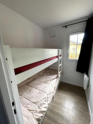 une petite chambre avec un lit superposé avec une fenêtre dans l'établissement Maison 3 pièces 6 personnes proche golf et océan, à Lacanau
