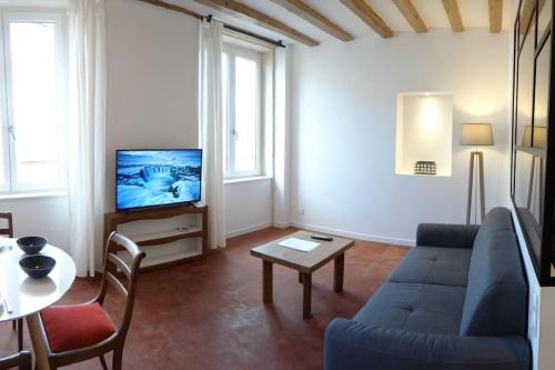 sala de estar con sofá azul y TV en T2 tout équipé au beau milieu du centre historique, en Villefranche-sur-Saône