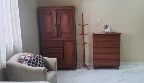 a living room with a dresser and a chair at Hospedaria Salém in Soure