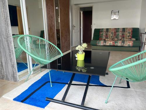 twee groene stoelen en een tafel in de woonkamer bij Cool Appart sur Croisette Palm Beach in Cannes